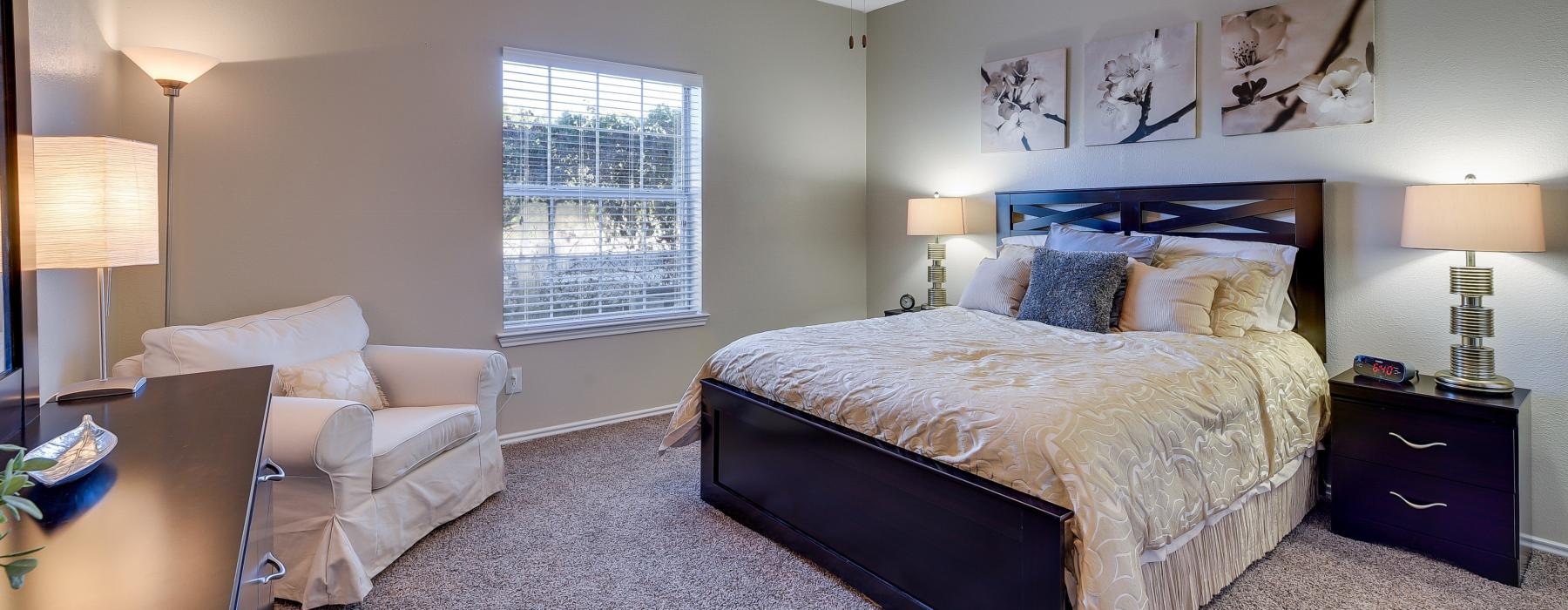 a carpeted bedroom with a bed and a fan
