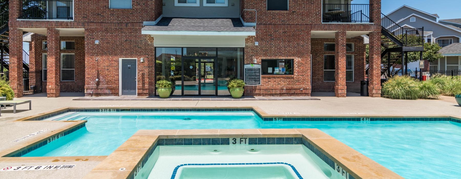 a large brick building with a swimming pool in front of it
